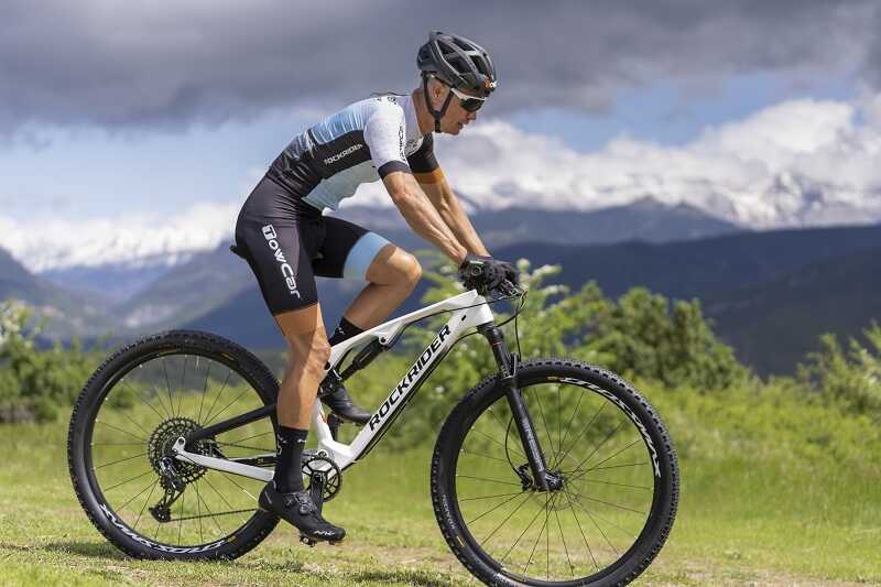 Mężczyzna w okularach rowerowych i kasku jedzie na rowerze MTB