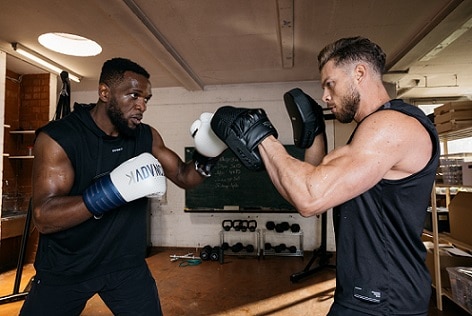 mężczyźni trenujący boks w rękawicach i tarczach bokserskich