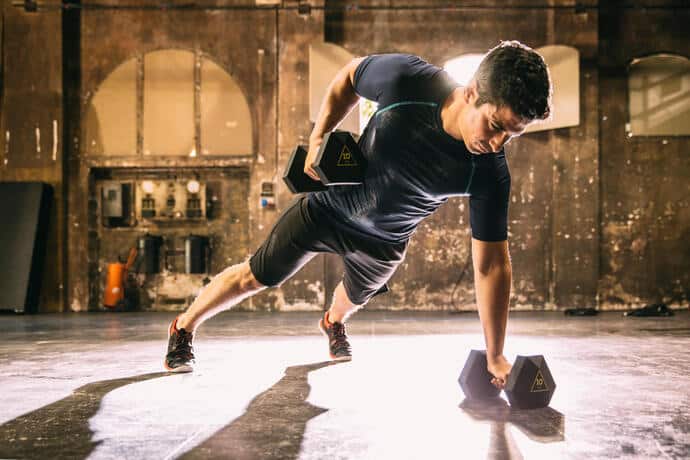 mężczyzna w odzieży fitness trenujący z hantlami